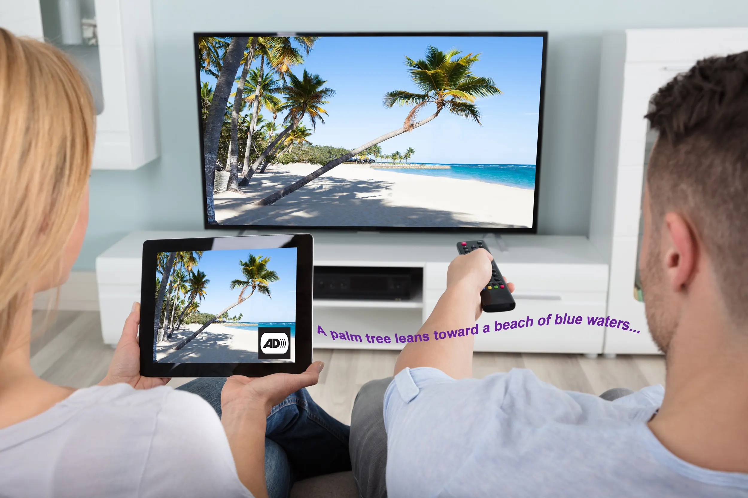 Two people watching TV. The same image from the TV appears on a tablet. Next to the AD icon on the tablet.