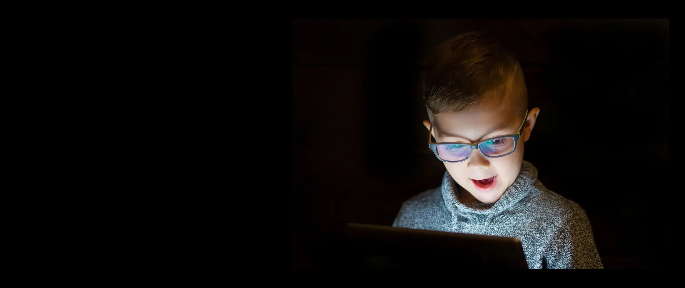 A kid looks at a tablet with awe.
